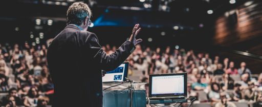 a presenter looks over a crowd of people